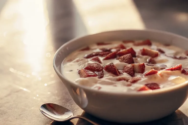 Recheio cremoso de Leite Ninho com morangos frescos picados, textura aveludada branca e rosa, recheio gourmet para bolos e sobremesas.