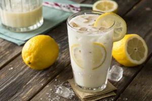 Copo de limonada suíça gelada com pedaços de limão e gelo.