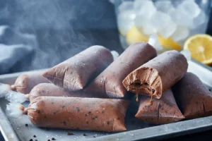 Sacolé de brigadeiro cremoso chocolate escuro com cobertura brilhante, picolé gelado brasileiro em saquinho plástico com textura aveludada e fios de chocolate.